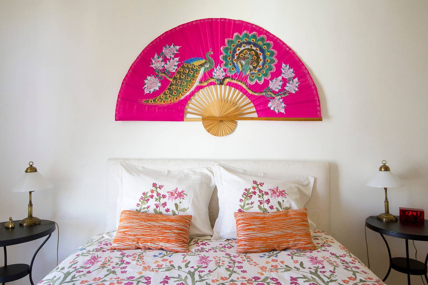 Настенный розовый веер в интерьере спальни